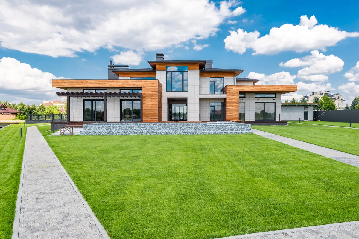 Floor-to-ceiling glass doors and panoramic windows on a modern two-story home